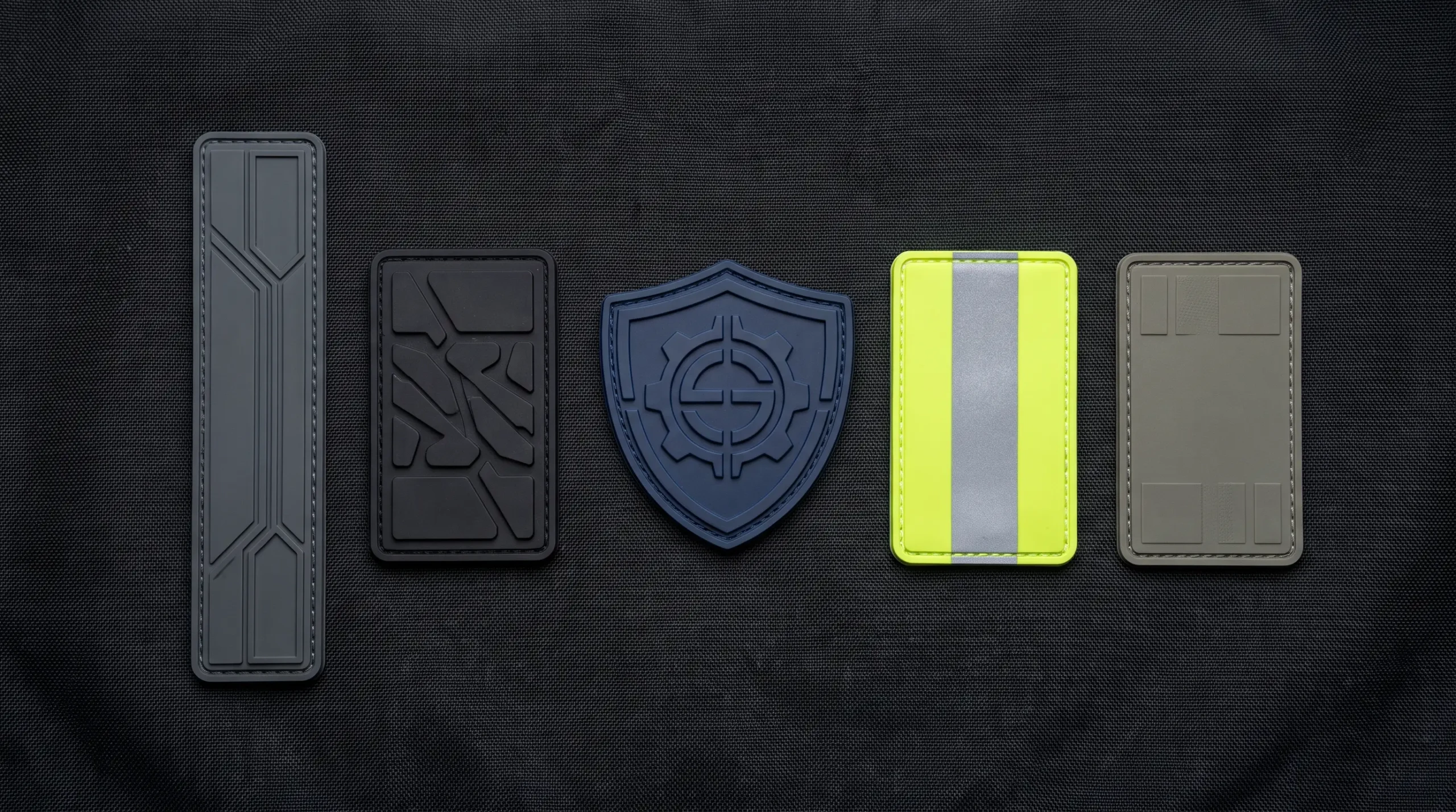 Five moulded rubber security patch formats on dark tactical fabric